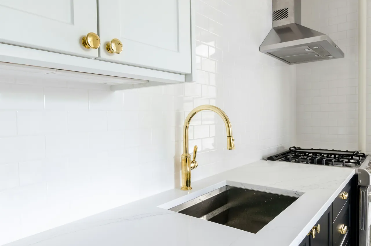 Brass kitchen faucet over an undermount sink