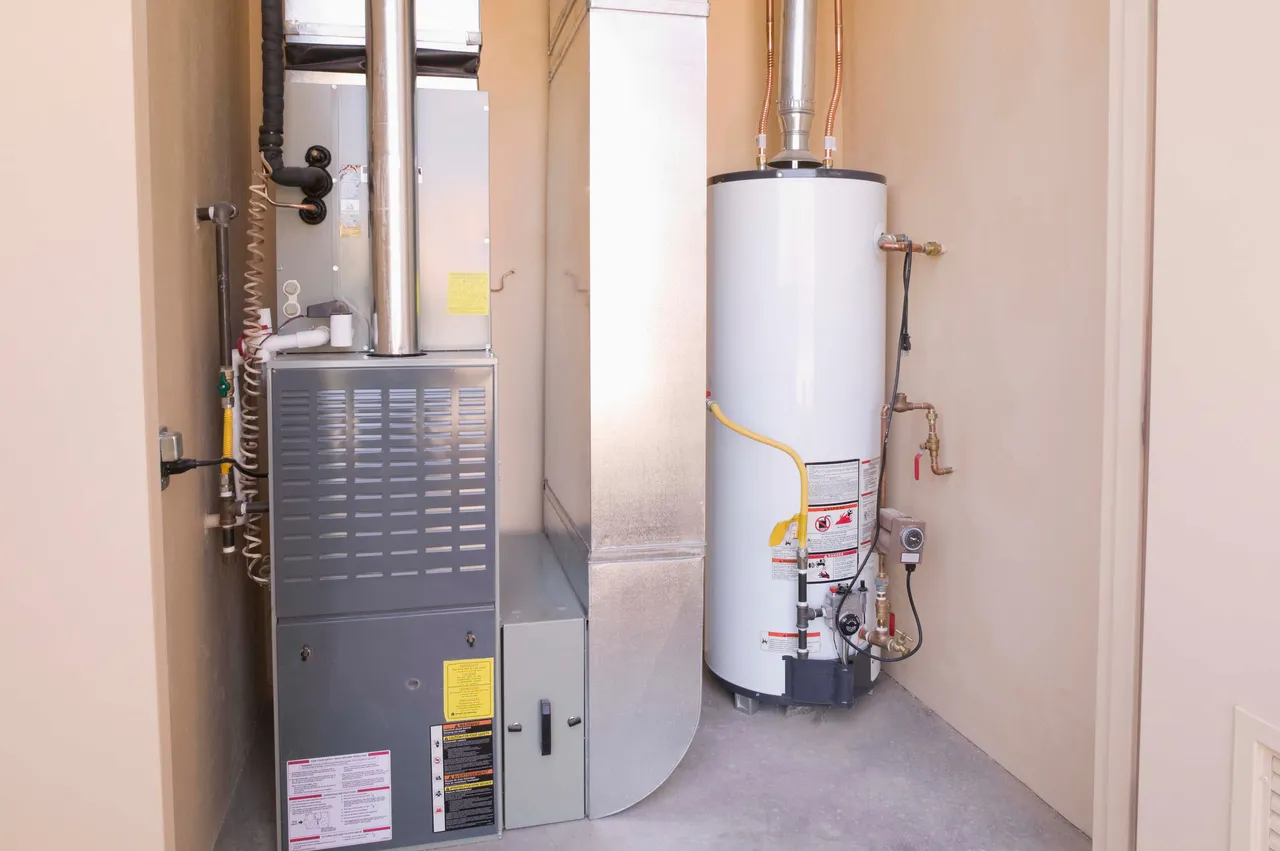 Tank water heater and furnace side by side in a utility closet